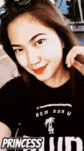 a woman wearing a black shirt that says rom sun u