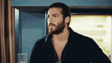 a man with a beard wearing a black shirt and a necklace