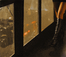 a woman in thigh high boots stands in front of a window looking out