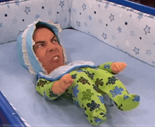 a doll with a man 's face on it is in a crib