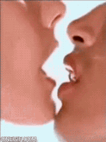a close up of two people kissing with the website onegif.com in the background