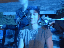 a man wearing a bandana and a necklace with a star on it is being interviewed