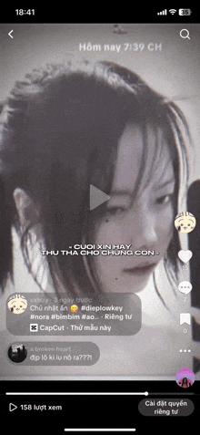 a phone screen shows a video of a girl with a ponytail