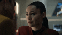 a woman in a red jacket is looking at a man
