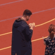 a man and a woman are standing on a track .
