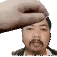 a hand is touching a man 's forehead with a beard .