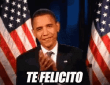 barack obama is clapping in front of an american flag