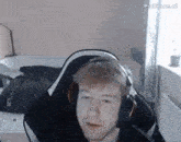a man wearing headphones is sitting in a chair in a bedroom .