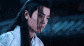 a man with long black hair is wearing a white shirt with a dragon on it