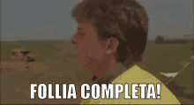 a man in a yellow shirt with the words follia completa below him