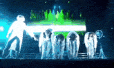 a group of people bending over on a stage with a green background