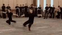 a group of people are practicing martial arts in a gym .