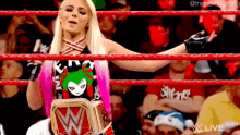 a woman in a wrestling ring holding a wwe championship belt