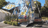 a woman stands in front of a carnival ride called the astro wheel