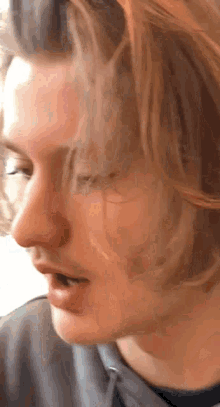 a close up of a man 's face with a gray shirt on