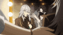 a woman wearing a mask is applying makeup to a man with long hair