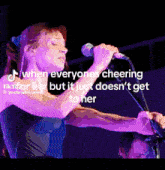 a woman singing into a microphone with the caption " when everyones cheering for her but it just does n't get to her