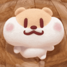 a stuffed animal with a mustache is sitting on a wooden table .