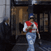 a woman with blue hair wearing sunglasses and a red jacket with the number 81 on it