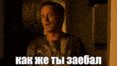 a man is standing in front of a window and says " как же ты заебал " in a foreign language