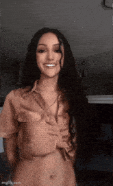 a woman with long hair is smiling and wearing a striped shirt .