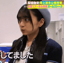 a woman wearing a hat and a sweater with chinese writing on the bottom right