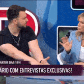 a man and a woman are sitting in front of a screen that says ario com entrevistas exclusivas