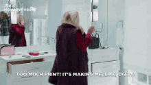 a woman standing in front of a mirror says too much print
