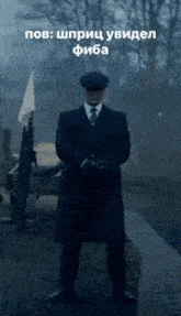 a man in a suit and hat is standing in the rain with a gun .