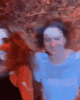 a blurry picture of two people standing next to each other with one wearing a blue shirt