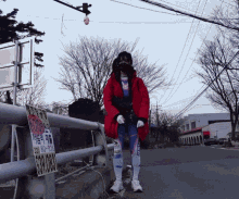 a person wearing a red coat stands in front of a yellow sign that says ' 000 ' on it