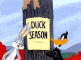 bugs bunny and daffy duck looking at a sign that says duck season
