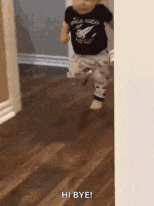 a baby is running on a wooden floor and says hi bye .