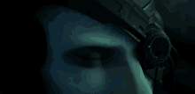 a close up of a person 's eye with a green light on