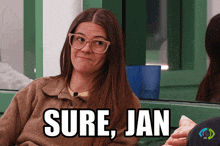 a woman wearing glasses and a brown sweater says " sure jan "
