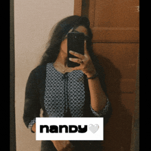 a woman is taking a picture of herself in a mirror with the name nandy visible