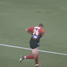 a soccer player is running on the field in front of a pepsi ad