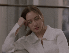 a woman in a white sweater is sitting on a couch