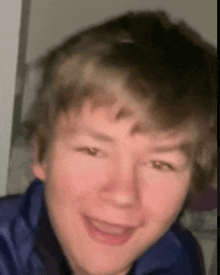 a close up of a young man 's face with a blurred background .