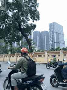 a man wearing a red helmet is riding a motorcycle with a license plate that starts with the letter a