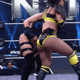 a woman in a yellow and black outfit with the word bitch on her shorts