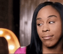 a woman with long black hair is making a funny face .