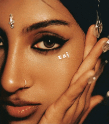 a close up of a woman 's face with the letters rai on her forehead