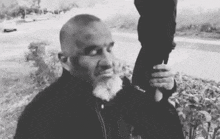 a black and white photo of a man with a beard holding a person .