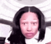 a close up of a woman making a funny face while wearing a white shirt .