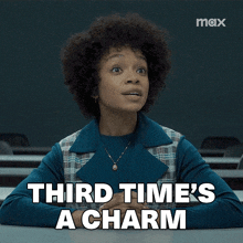 a woman sitting at a desk with the words " third time 's a charm " on the screen