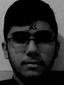 a black and white photo of a man wearing glasses and a tattoo on his forehead .