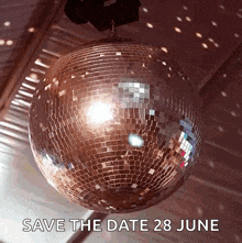a disco ball is hanging from the ceiling with the words save the date 28 june below it