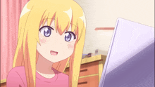 a girl with blonde hair and blue eyes is looking at a laptop screen