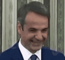 a man in a suit and tie is smiling and looking at the camera .